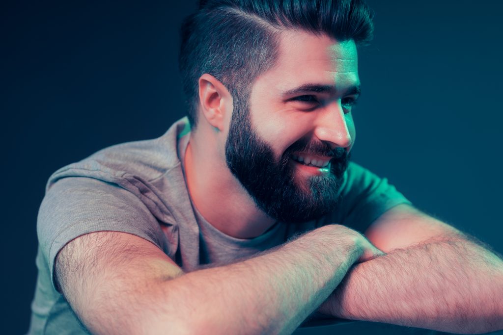 Neon portrait of a young attractive man in the studio. Close-up