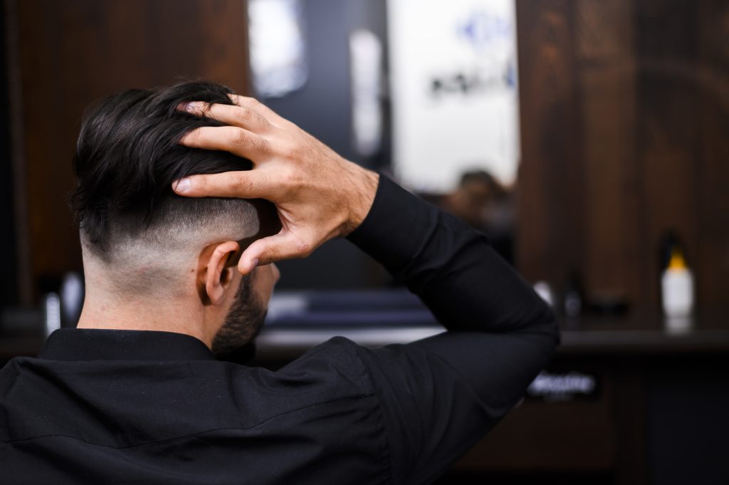 vista-posterior-del-hombre-arreglando-su-cabello