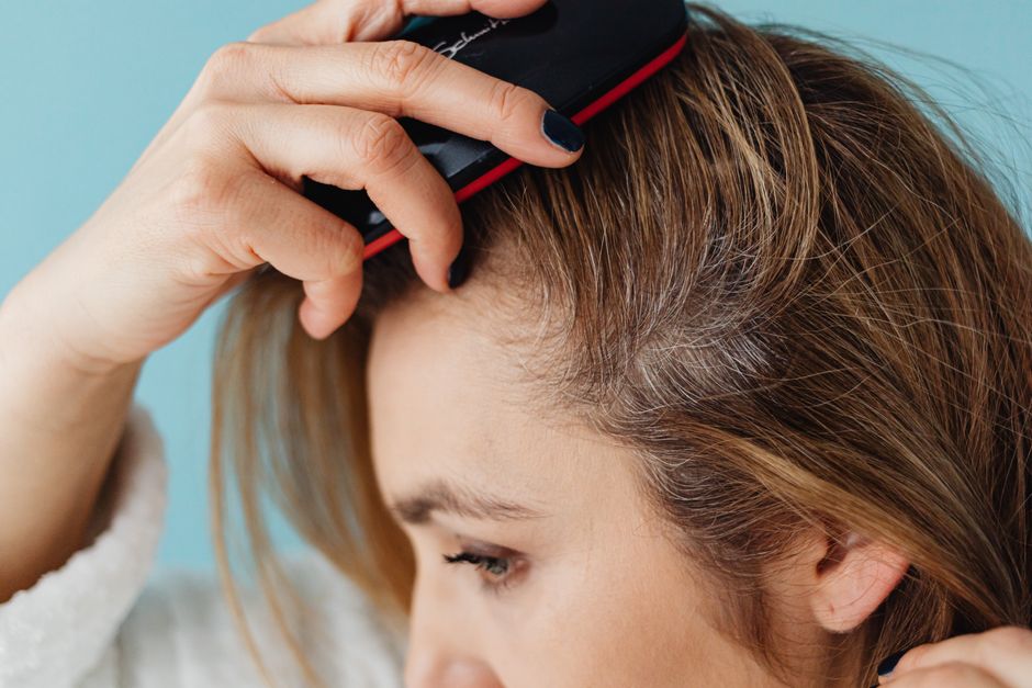 Mujer joven observando la pérdida de cabello en la coronilla